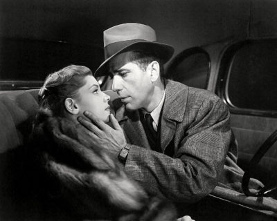 Bogart kijkt vertederd naar zijn tegenspeelster Bacall in The Big Sleep uit 1946. Credits: Warner Bros.