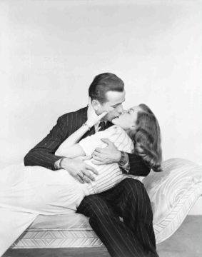 Humphrey Bogart kust zijn geliefde Lauren Bacall, een publiciteitsfoto voor film The Big Sleep. Credits: Warner Bros.
